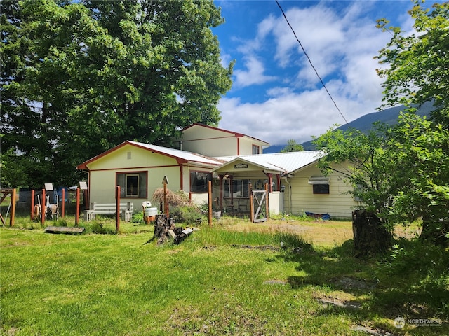 rear view of property featuring a lawn