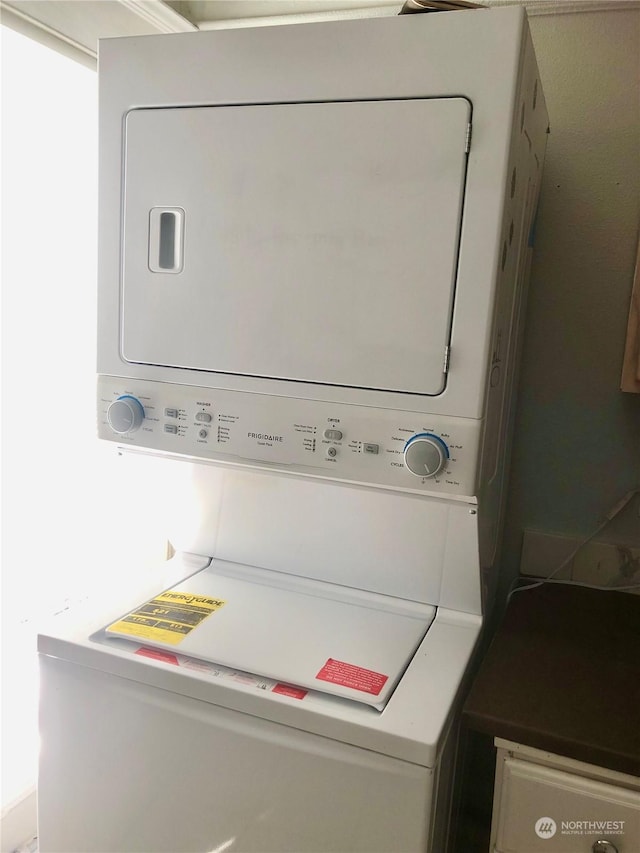 washroom featuring stacked washer and dryer