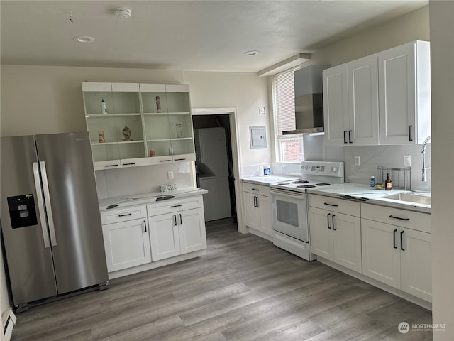 kitchen featuring stainless steel fridge, white electric range oven, light wood-type flooring, white cabinets, and sink