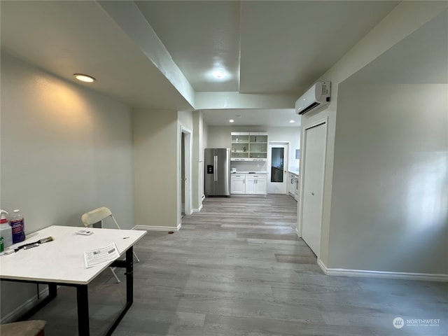 hallway featuring light wood-type flooring and a wall mounted air conditioner