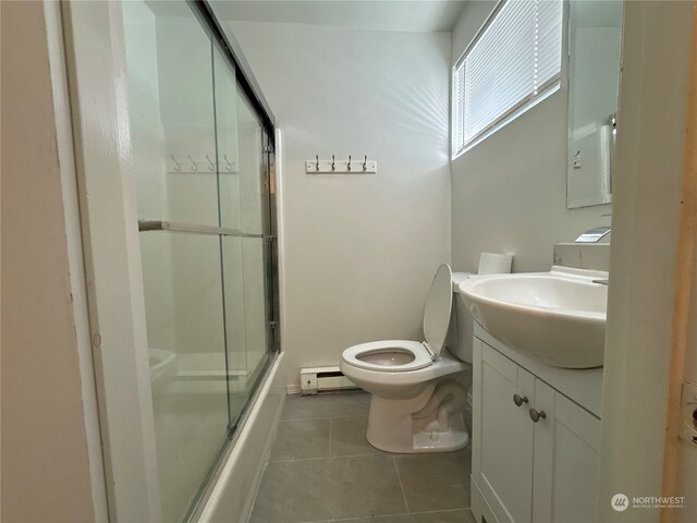 full bathroom with baseboard heating, tile patterned flooring, vanity, toilet, and combined bath / shower with glass door