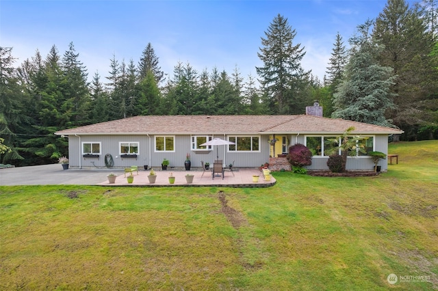 view of front of house featuring a patio and a front lawn