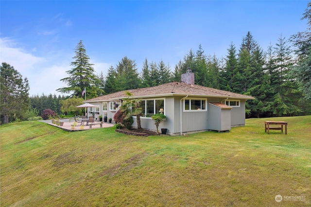 rear view of house with a yard and a patio