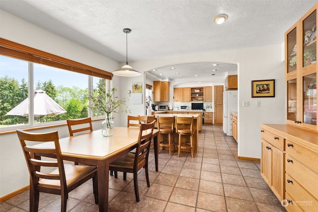 tiled dining room with a textured ceiling