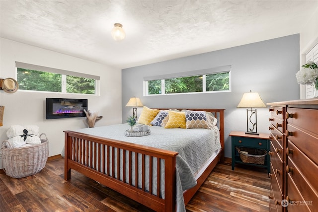 bedroom featuring dark hardwood / wood-style flooring and multiple windows