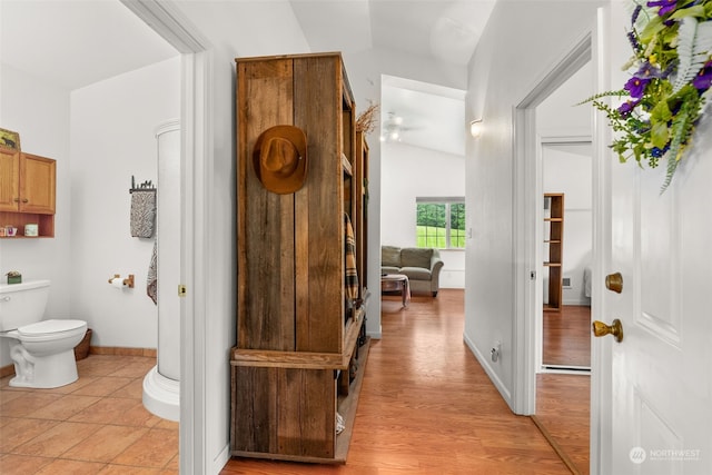 bathroom featuring hardwood / wood-style flooring, vaulted ceiling, and toilet