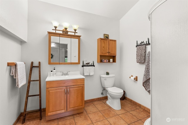 bathroom with tile patterned flooring, vanity, and toilet