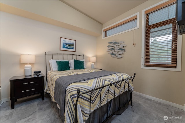 bedroom featuring lofted ceiling and baseboards