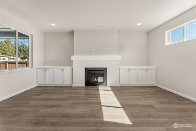 unfurnished living room with hardwood / wood-style floors and a healthy amount of sunlight