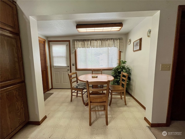 dining room with a textured ceiling and light tile floors