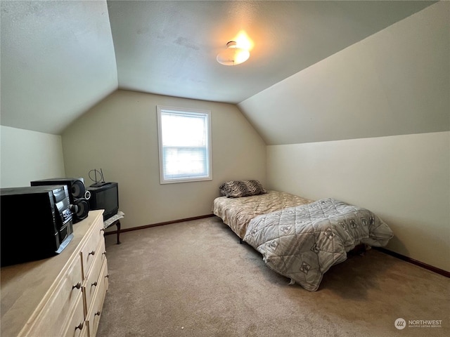 bedroom with light carpet and lofted ceiling