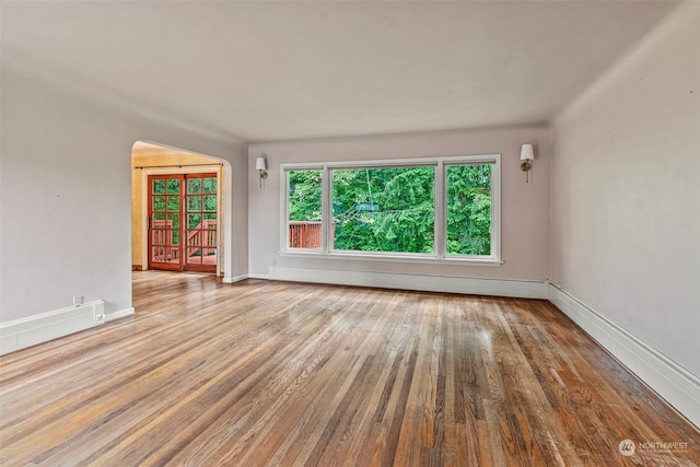 unfurnished room with light hardwood / wood-style flooring and a baseboard heating unit