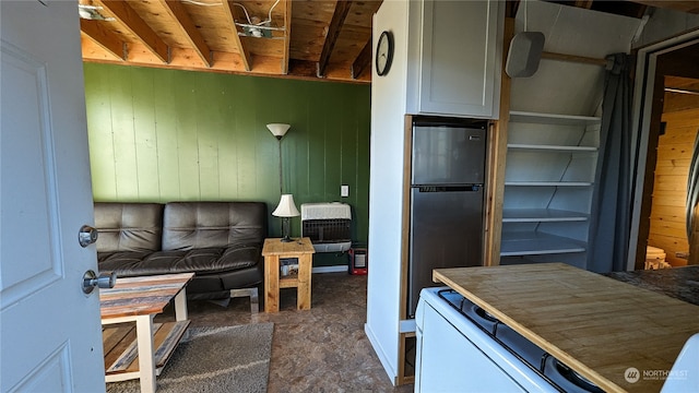 kitchen with freestanding refrigerator and wooden walls