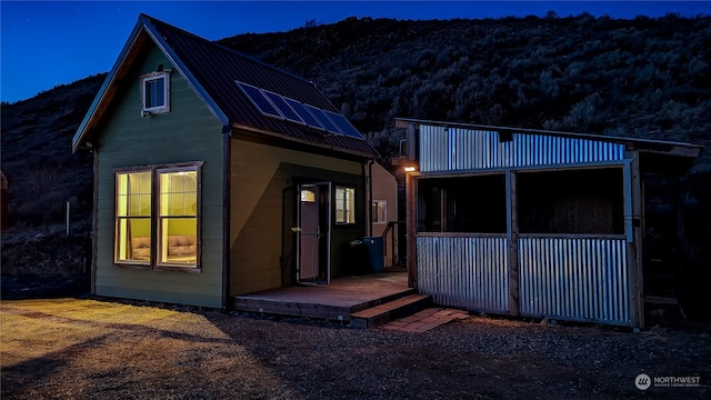 view of front facade featuring metal roof and an outbuilding