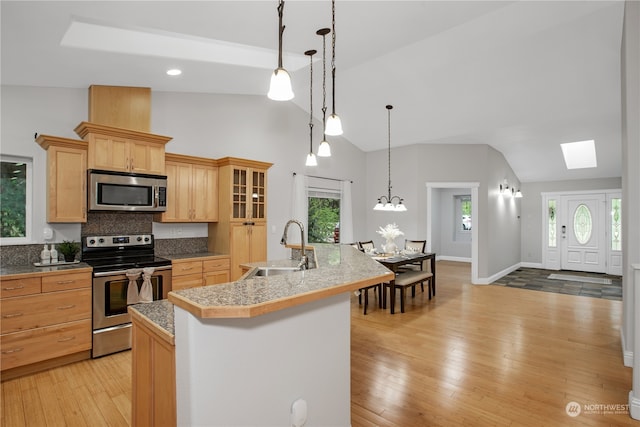 kitchen featuring decorative light fixtures, sink, a wealth of natural light, and appliances with stainless steel finishes