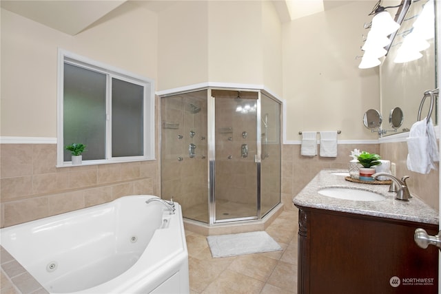 bathroom featuring tile flooring, separate shower and tub, tile walls, and large vanity