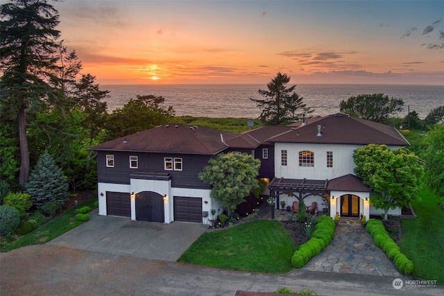 view of front facade featuring a water view and a garage