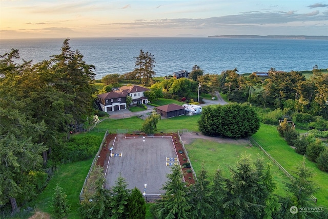 aerial view at dusk featuring a water view