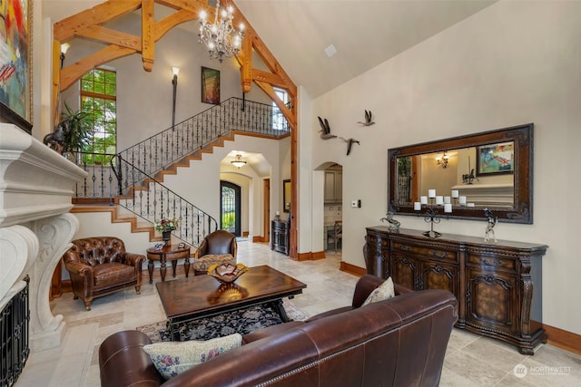 living room featuring high vaulted ceiling, a tile fireplace, a chandelier, and light tile floors