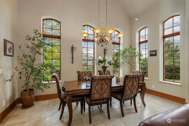 tiled dining space with a towering ceiling and a chandelier