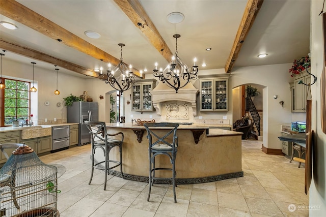 kitchen featuring beam ceiling, decorative light fixtures, stainless steel fridge with ice dispenser, and a kitchen island