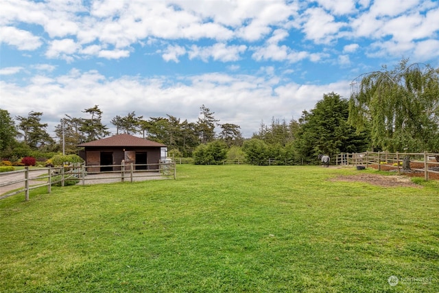 view of yard featuring an outdoor structure and a rural view