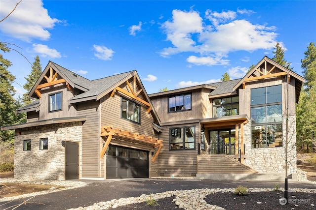 view of front facade with an attached garage and stone siding
