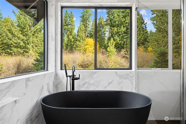 interior space featuring a soaking tub and tile walls