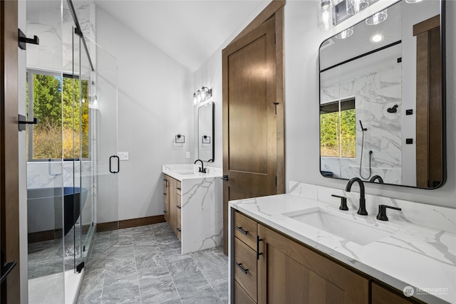 full bathroom featuring marble finish floor, a marble finish shower, two vanities, and a sink