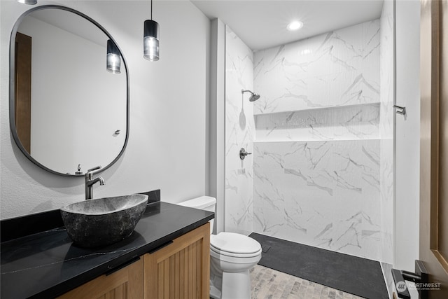 bathroom featuring toilet, a marble finish shower, vanity, and recessed lighting