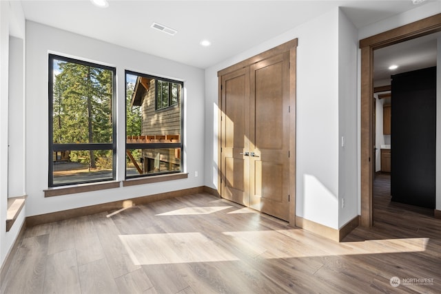 spare room with baseboards, wood finished floors, visible vents, and recessed lighting