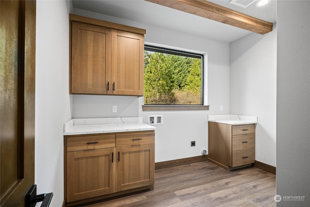 washroom featuring hookup for a washing machine, wood finished floors, electric dryer hookup, cabinet space, and baseboards