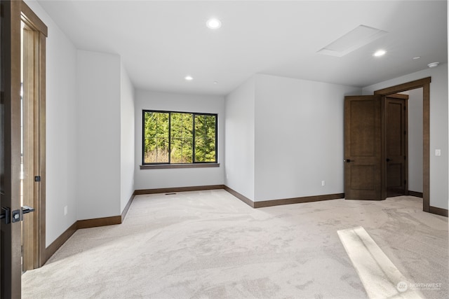 unfurnished room featuring attic access, recessed lighting, light carpet, and baseboards