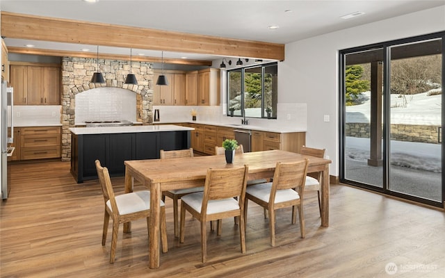 dining room with light wood finished floors, beamed ceiling, and recessed lighting