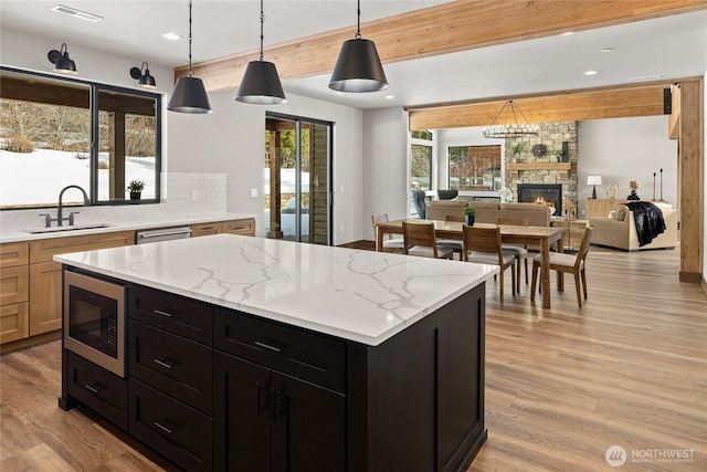 kitchen featuring built in microwave, visible vents, a sink, and light wood-style flooring