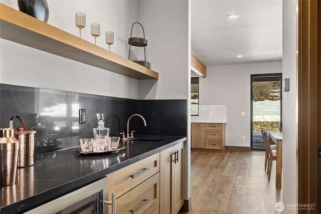 kitchen featuring wine cooler, light wood finished floors, open shelves, backsplash, and a sink