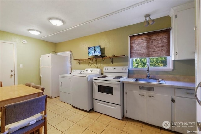 kitchen with washer and dryer, white cabinetry, sink, light tile patterned floors, and white appliances