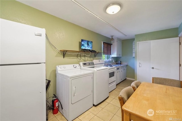 laundry room with sink, light tile patterned floors, and washer and dryer