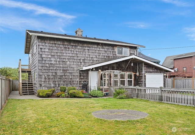 back of house with a garage and a lawn