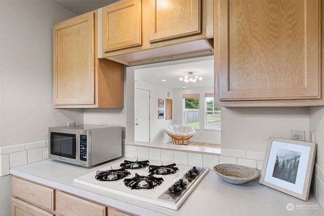 kitchen featuring light brown cabinets and white gas stovetop