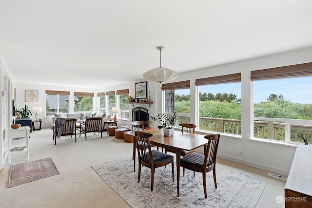 carpeted dining space with a fireplace