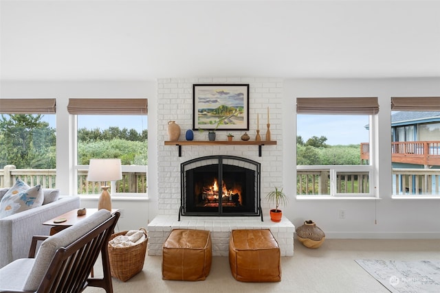 living room featuring a healthy amount of sunlight, a brick fireplace, and carpet floors