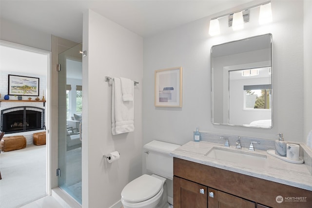 bathroom with vanity with extensive cabinet space, an enclosed shower, and toilet