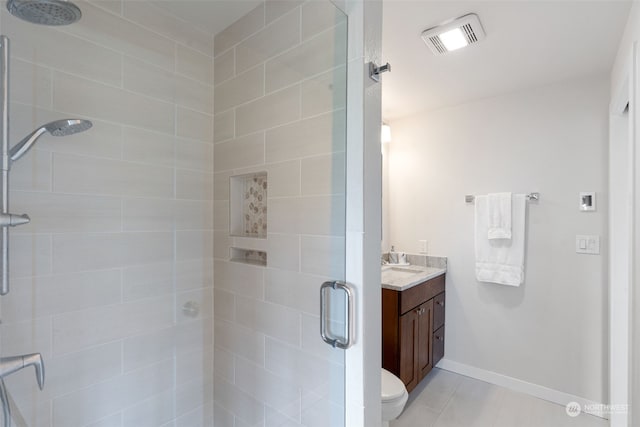 bathroom featuring tile floors, an enclosed shower, toilet, and vanity