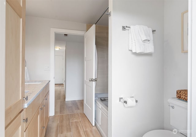 bathroom with hardwood / wood-style flooring, vanity, and toilet