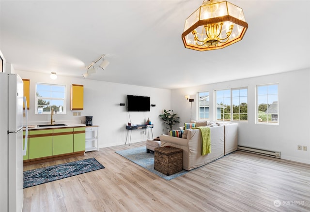 living room with sink, plenty of natural light, a baseboard radiator, and light hardwood / wood-style floors