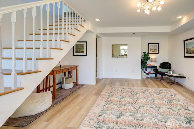 entrance foyer with an inviting chandelier, stairs, wood finished floors, baseboards, and recessed lighting