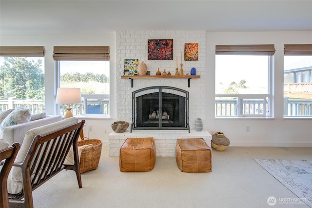 carpeted living room featuring a brick fireplace and a wealth of natural light