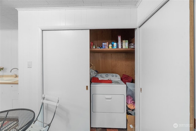 laundry room featuring washer / clothes dryer, wooden walls, and sink