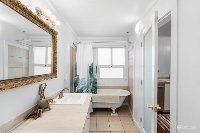 bathroom with tile patterned flooring, ornamental molding, vanity, and a healthy amount of sunlight